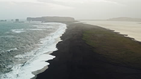 cinematic aerial drone shot of black sand beach of reynisfjara, vik - iceland