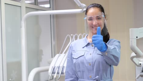 smiling dentist showing thumbs up
