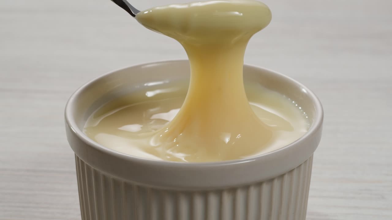 leche condensada con azúcar, abre una lata de un ingrediente cremoso, revelando con éxito su delicioso contenido dentro