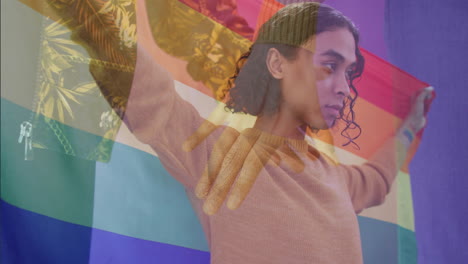 animation of diverse gay male couple holding hands over biracial gay man holding rainbow flag