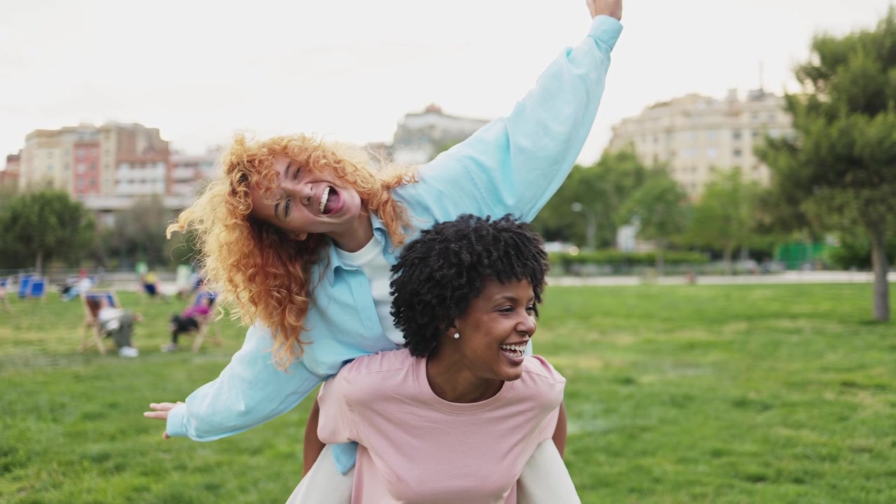 Joyful Multi-ethnic Women Playing Piggyback in Park