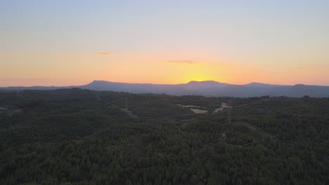 Vistas-Aéreas-De-Una-Puesta-De-Sol-Con-Las-Montañas-Y-Los-Molinos-De-Viento-Al-Fondo