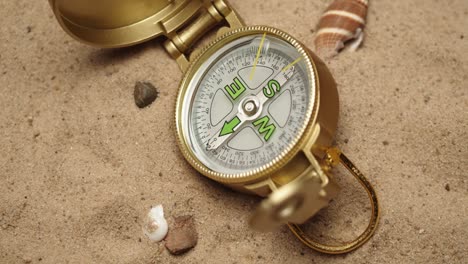 gold compass on sand background close-up, focusing of golden compass. traveling and tourism concept, navigation