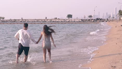 people-join-hands-and-run-along-tropical-beach-slow-motion