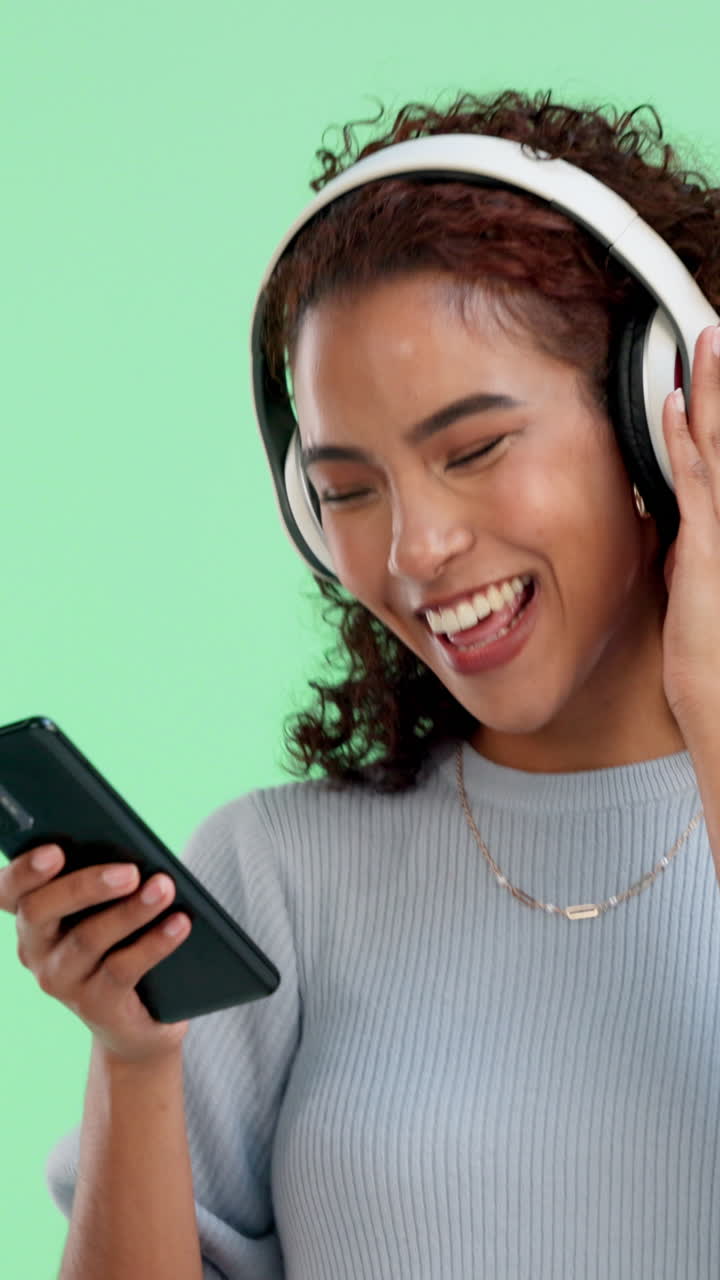 Giovane donna felice che ascolta musica e ride sullo smartphone