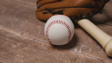 Cerrar-Estudio-De-Béisbol-Bodegón-Con-Bate-De-Madera-Y-Pelota-En-Guante-De-Receptor-En-Piso-De-Madera-4