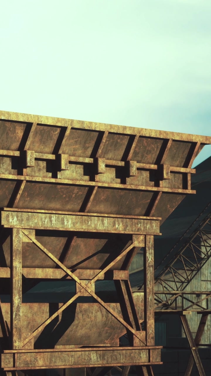 Antiga estrutura industrial se destaca contra o céu em uma área rural ao pôr do sol