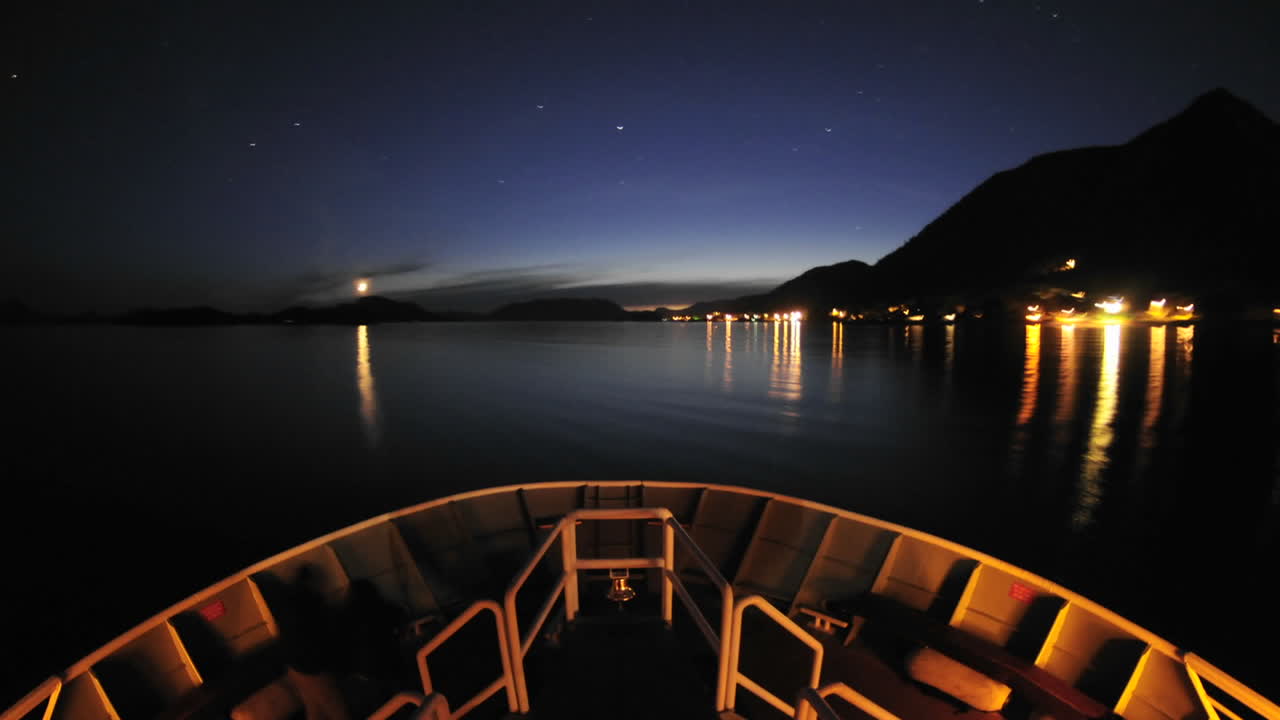 punto de vista de un barco que sale de sitka por la noche y navega por el estrecho de olga en el sureste de alaska