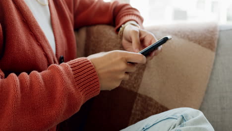 manos, teléfono y mujer en el sofá escribiendo en social
