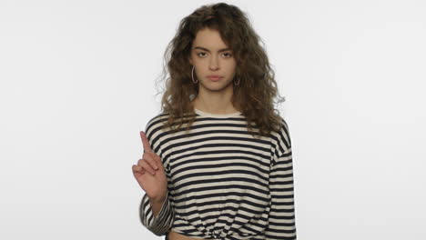 Serious-woman-showing-no-sign-in-studio.-Portrait-of-girl-showing-stop-gesture