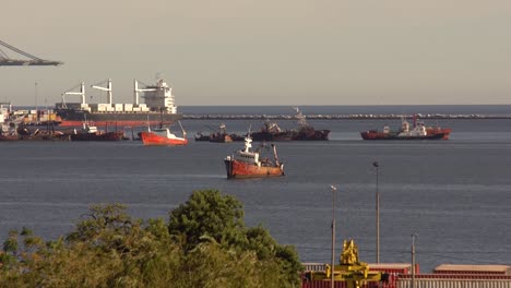 un viejo bote oxidado en el mar al lado del puerto y viejos botes rotos más grandes