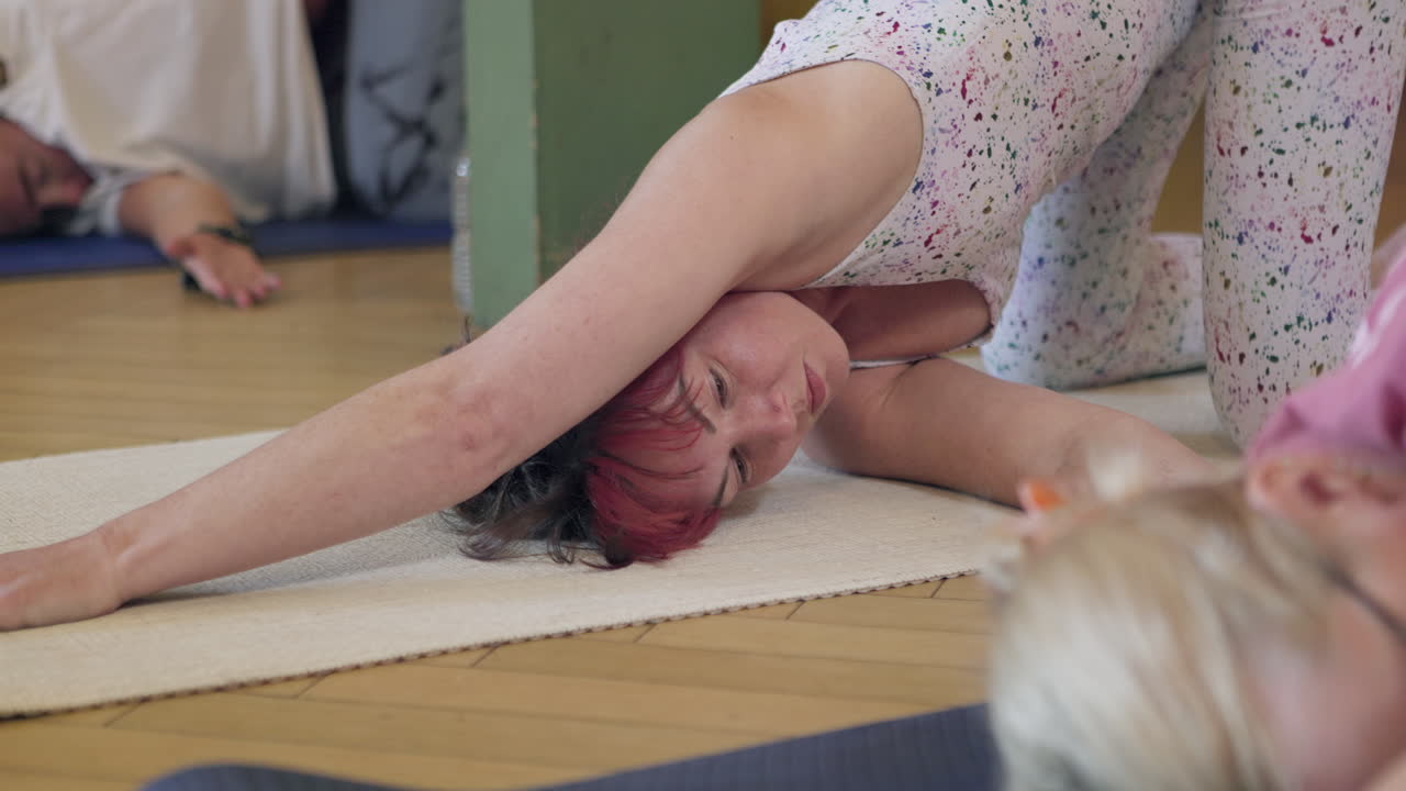 Yoga class with people stretching on mats