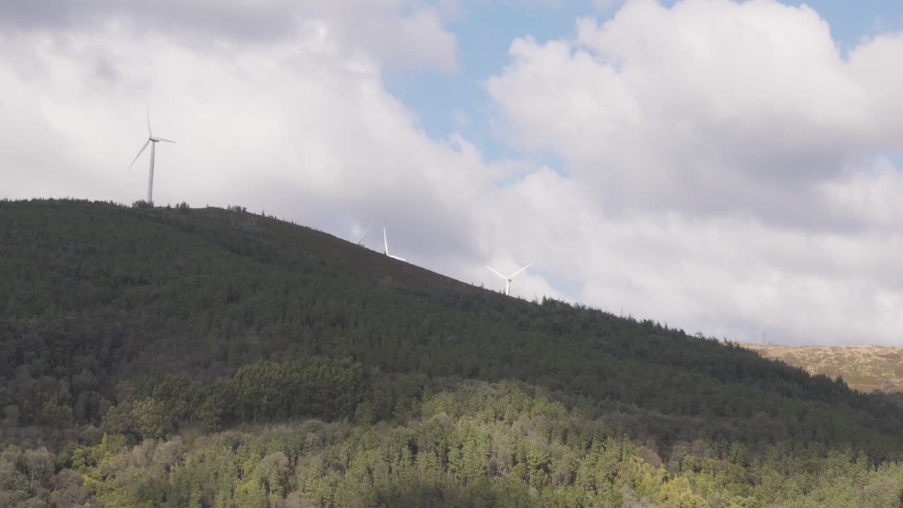 Large windmills spinning slowly on a cloudy day