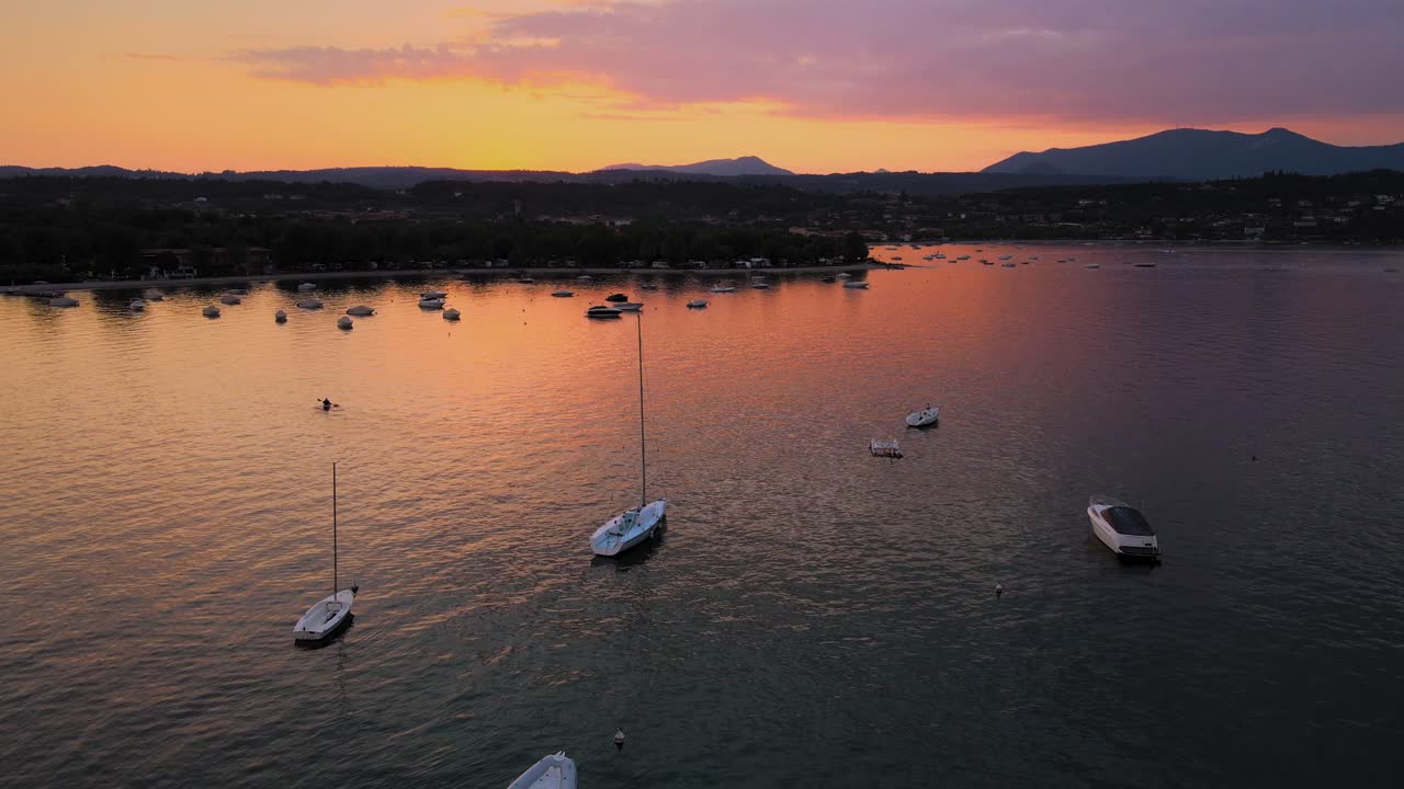 Cielo magico al tramonto crepuscolare sopra la città di Salò e il lago di Garda, Italia