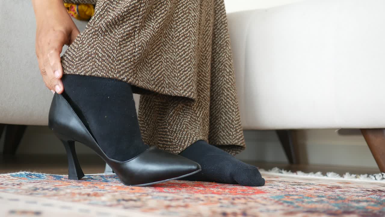 Woman struggling to put on high heels