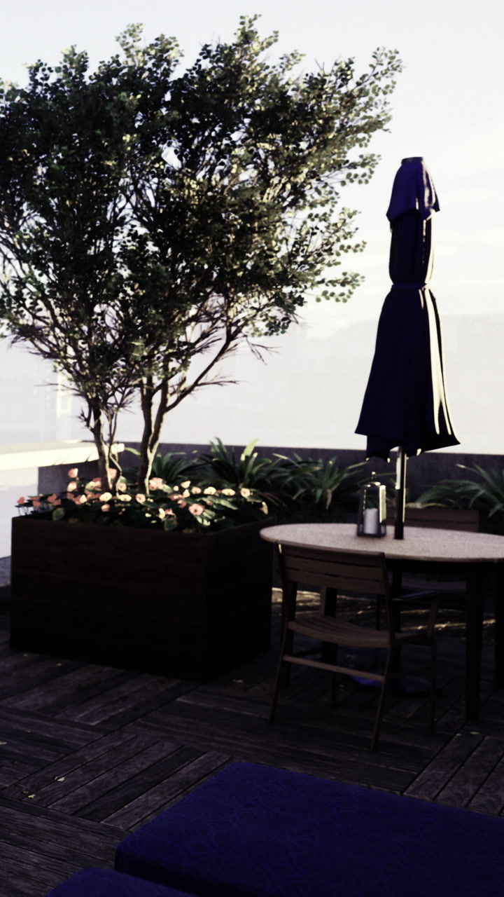 Open space with table and plants at a rooftop location during the day