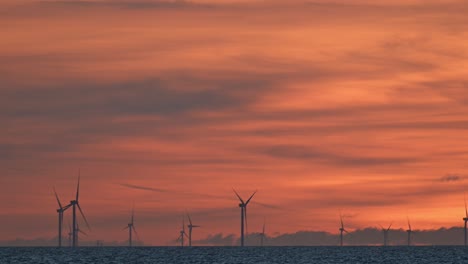 offshore wind farm and sunset colors in the north sea off the coast of the netherlands