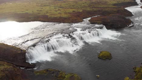 Sonnenlicht-Spiegelt-Sich-Im-Fließenden-Faxi-Wasserfall-Flussbach,-Island