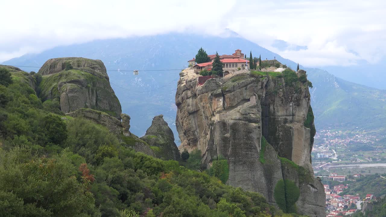 канатная дорога движется через пропасть к монастырю в греции метероа
