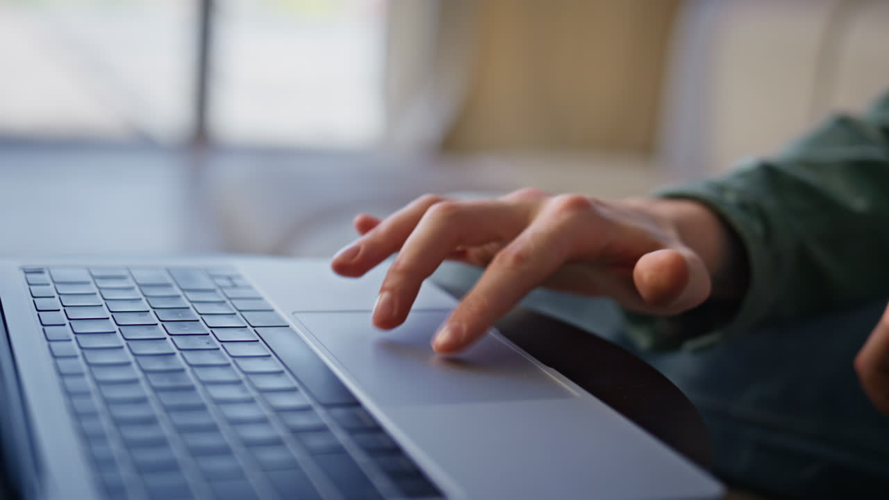 Closeup person typing laptop remotely. Man hands using touchpad in light office
