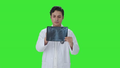 el médico indio chequeando el informe de rayos x pantalla verde