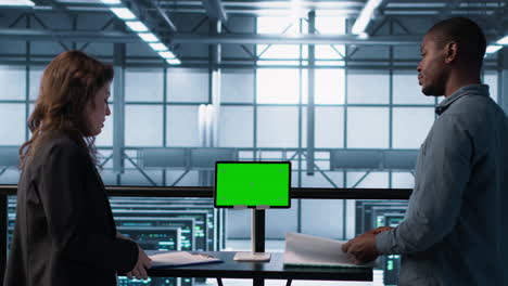 data center team using mockup green screen tablet, reviewing paperwork
