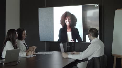 partner afroamericano che saluta i colleghi tramite videochiamata