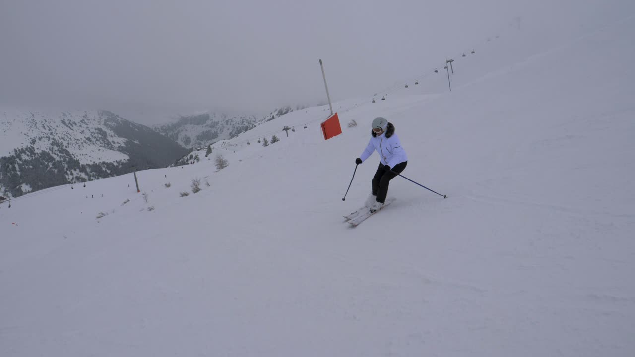 esquiador descendiendo tallando en la ladera en las montañas en invierno en la niebla