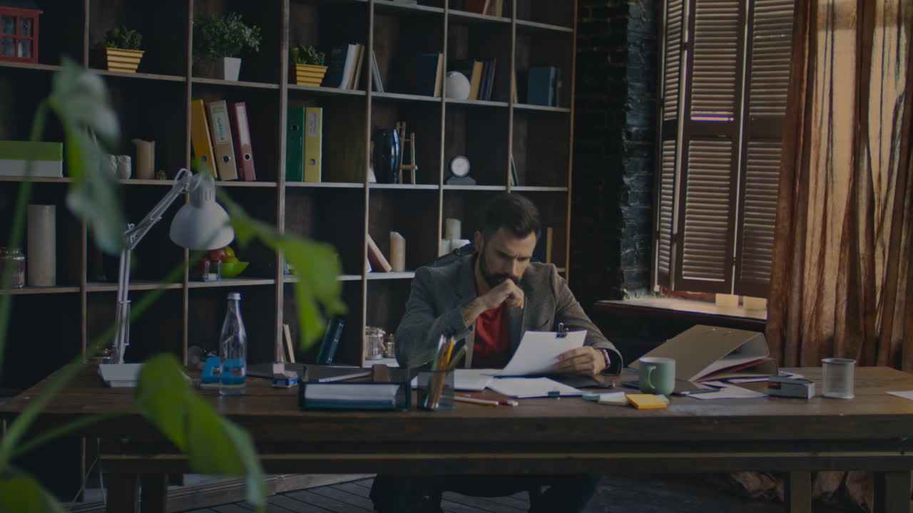 Businessman reading papers documents at desk. Businessman working in home office