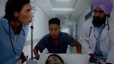 Busy-diverse-doctor-and-surgeons-talking-and-walking-with-patient-on-hospital-bed-in-slow-motion