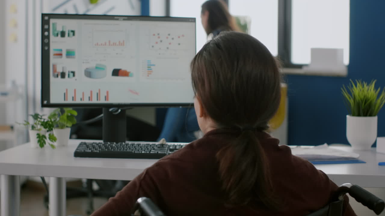 장애인 여성 관리자가  ⁇ 체어를 타고 직장에 다니고 있습니다.