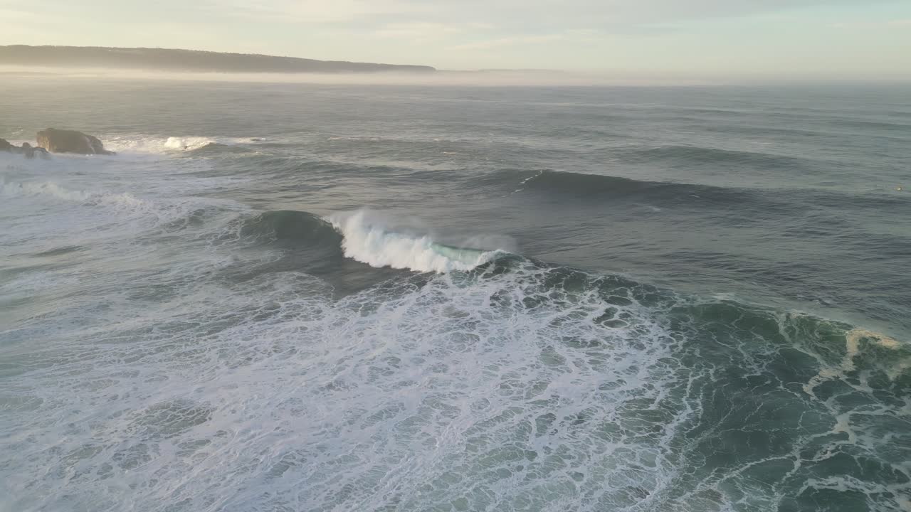 Surfer catching a wave, aerial view over Nazaré's coastline, Portugal, peaceful mood