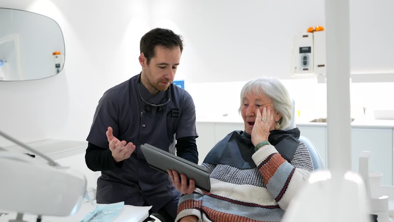Dentist consulting with elderly patient in dental clinic