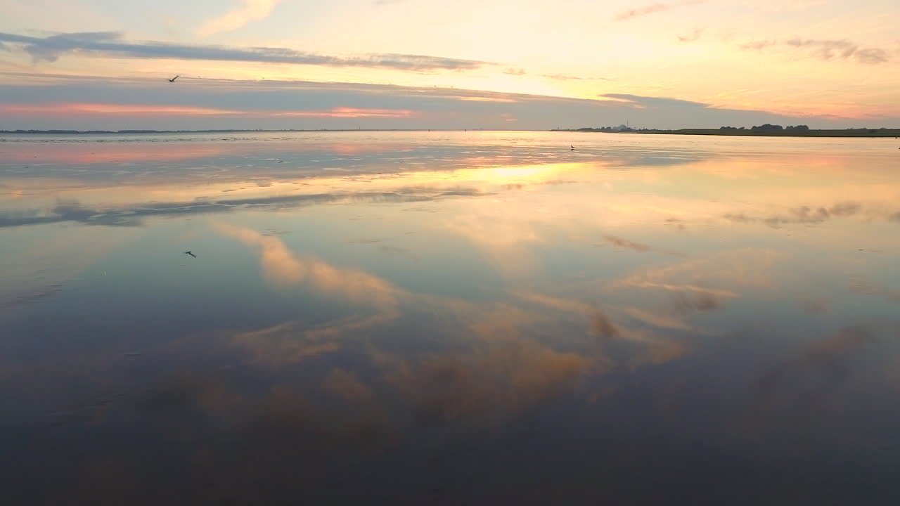 Sunset over Sea with flying Bird along Drone with Reflections in Water