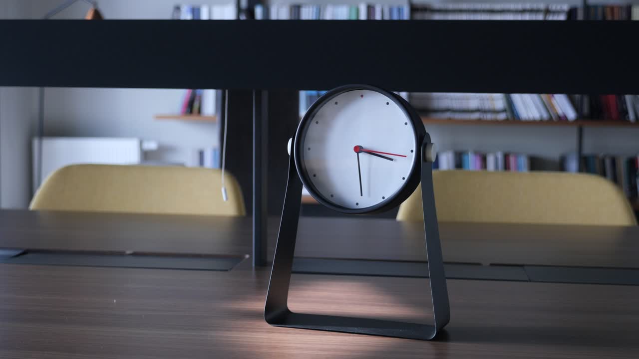 reloj de mesa moderno en un entorno parecido a una biblioteca