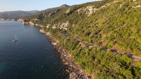 A-red-car-drives-along-the-coast-at-sunrise