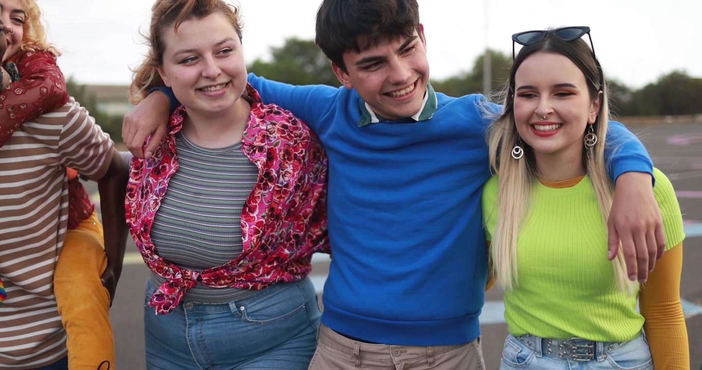 Bljje diverse groep jonge vrienden die elkaar buiten omhelzen en lachen