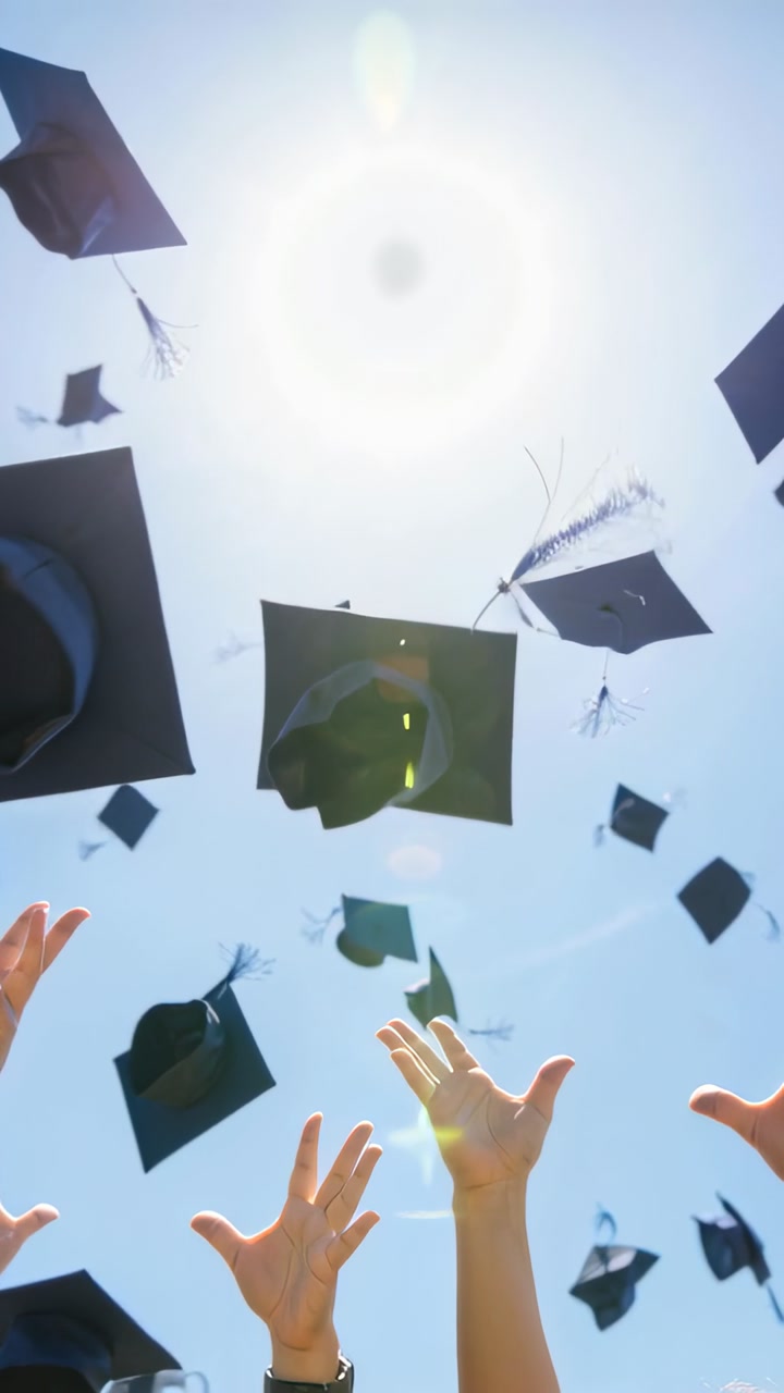 Launching graduates mortarboard caps and hands rising into noon sky celebrating graduation in gowns