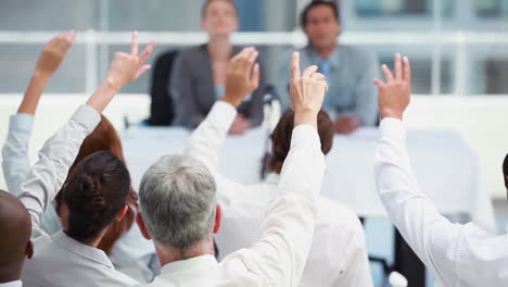 business people raising their hands to ask questions