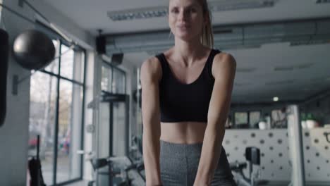 handheld view of young woman working out with kettlebell