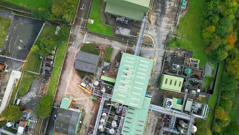 Aerial-footage-zooms-in-on-a-UK-industrial-chemical-plant,-highlighting-pipelines,-metal-constructions,-cooling-towers,-and-chemical-storage