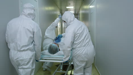 paramedics in protective uniform transporting coronavirus patient