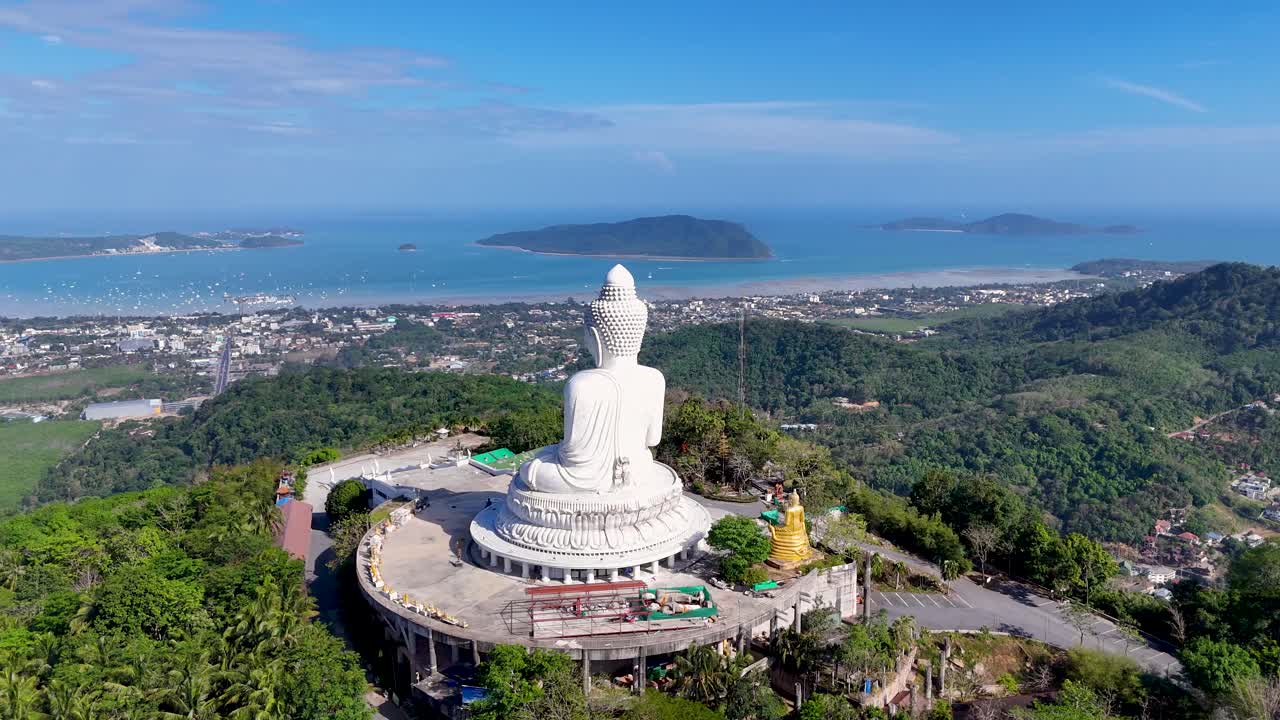 las imágenes de drones capturan la serena estatua del gran buda con vistas a los exuberantes paisajes y el mar de andamán en phuket, tailandia