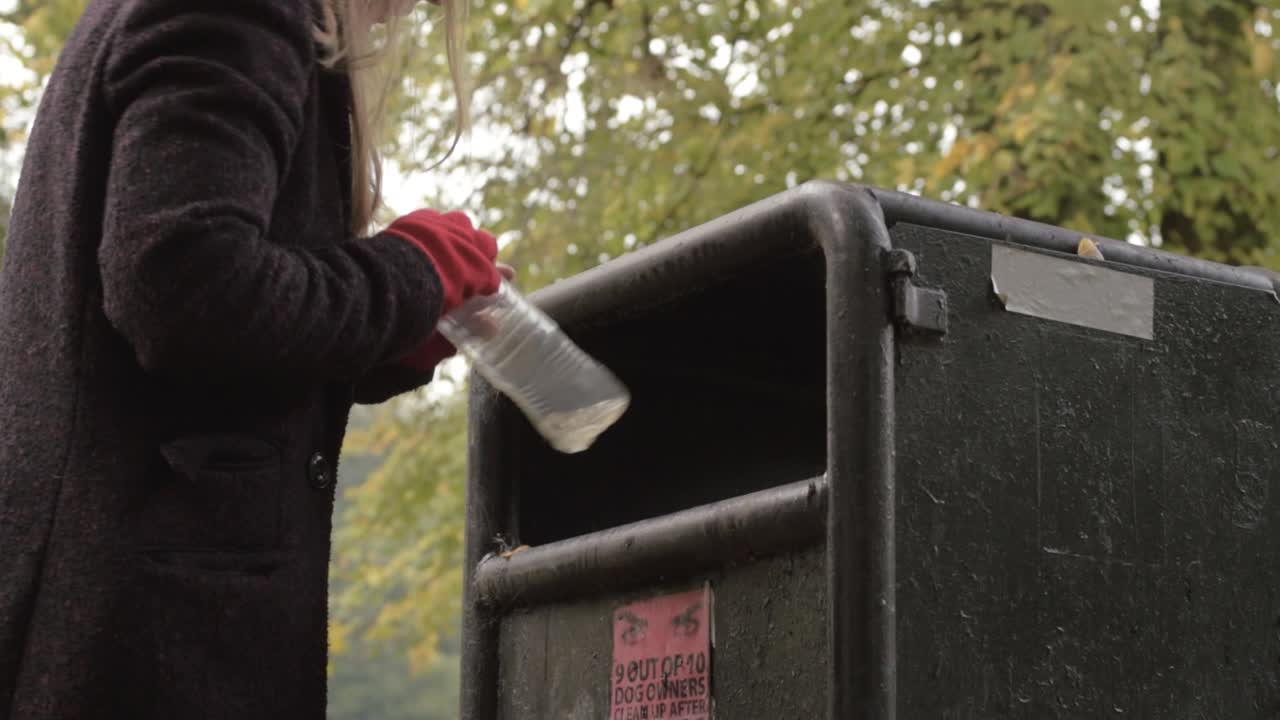 mujer tirando basura plástica en el contenedor del parque.