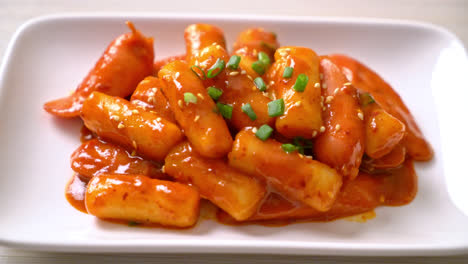 korean rice cake stick with sausage in spicy sauce - tteokbokki