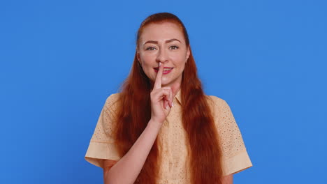 young woman presses finger to lips makes silence gesture sign do not tells secret stop gossip