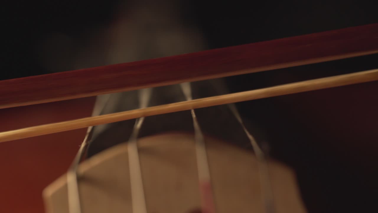primer plano macro de violonchelo, arco de violonchelo, violonchelo y cuerdas