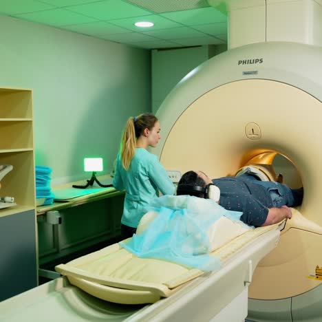 male patient in mri machine. medical laboratory worker controls mri scanner. doctor conducts emergency check up procedure.