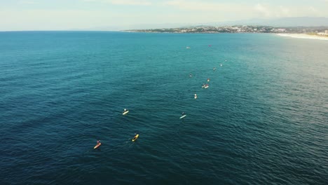 los paddle boarders se alinean en las aguas de puerto escondido.