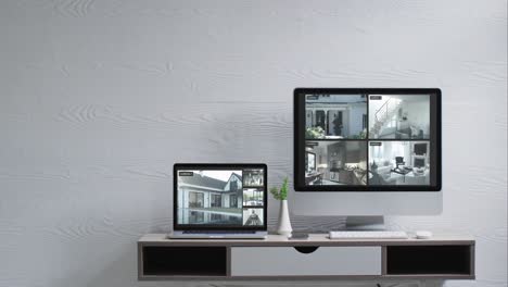 monitor de computadora montado en la pared y portátil en el escritorio con vistas de cámaras de seguridad en las pantallas, cámara lenta